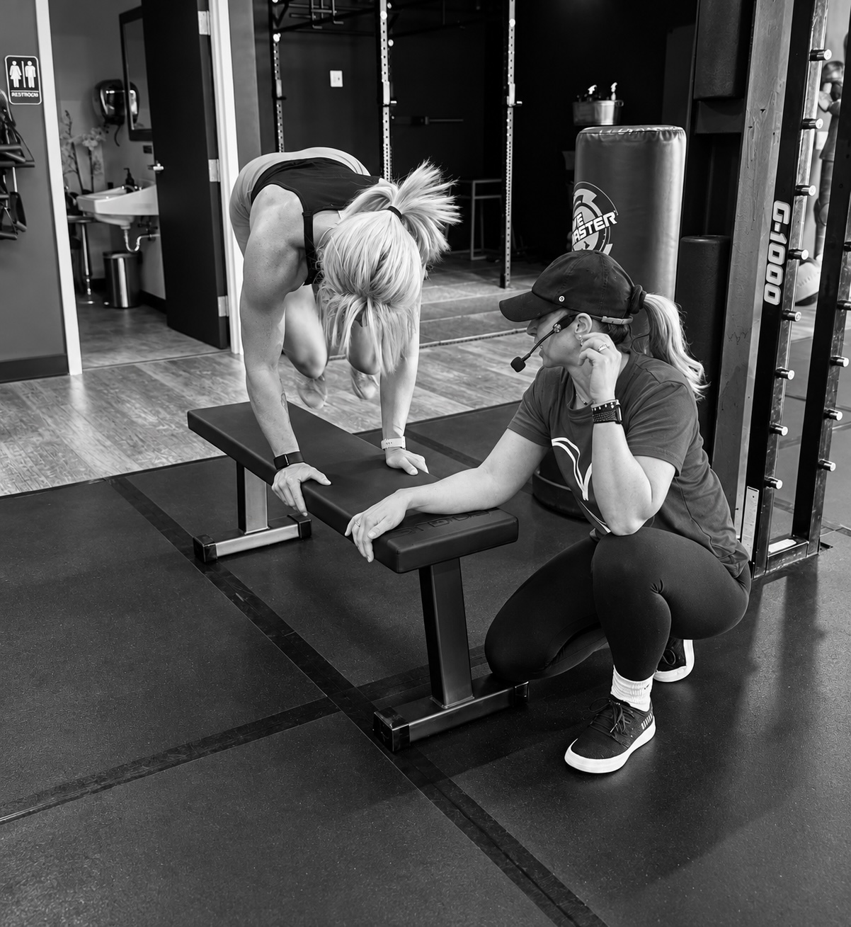 A coach adjusting a member's technique during a group training session