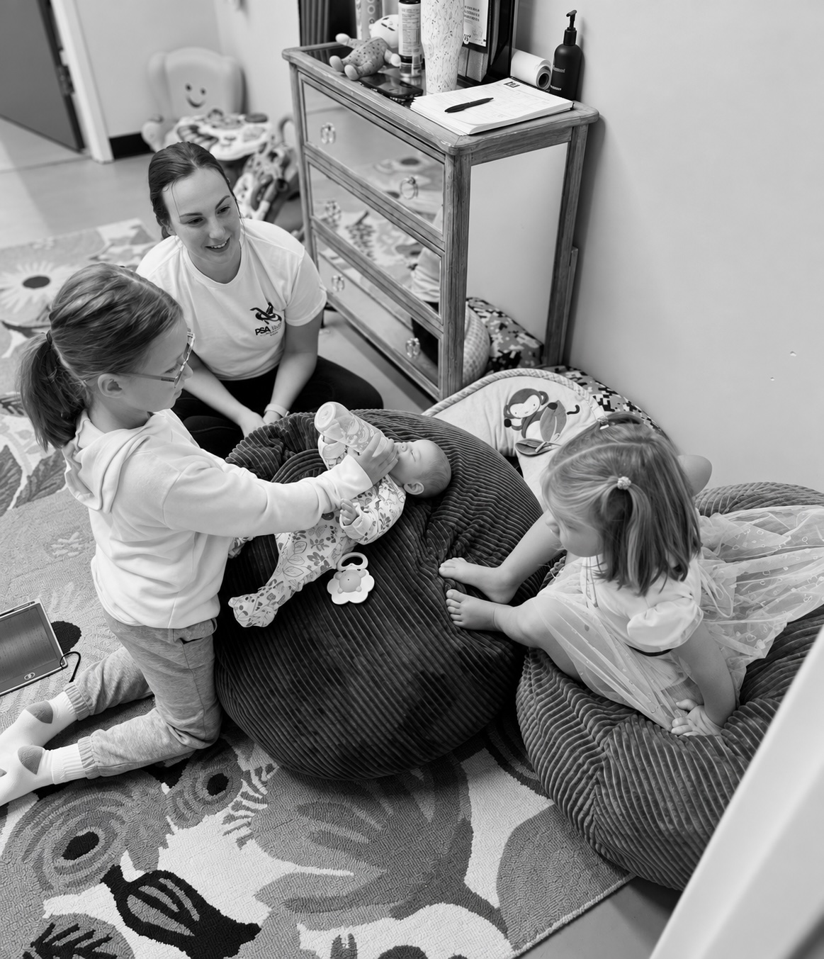 A Child Watch attendant playing with children in the Fitness Artist Child Watch room